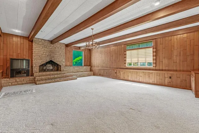 a view of an empty room with a fireplace and a window