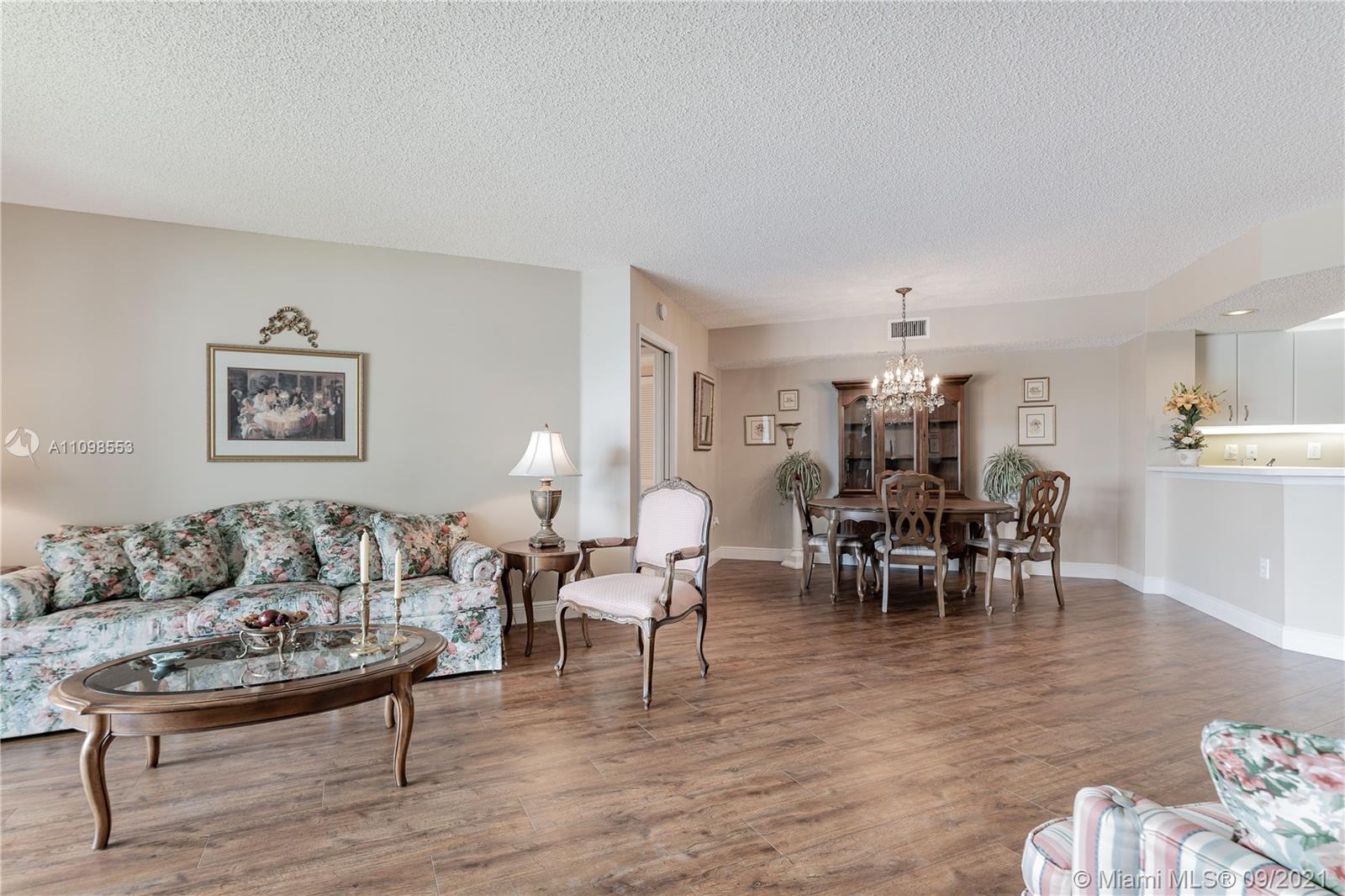 9563 Weldon Circle, Unit D207 Tamarac, FL 33321 - Photo 22 of 40 a living room with furniture and a dining table with wooden floor