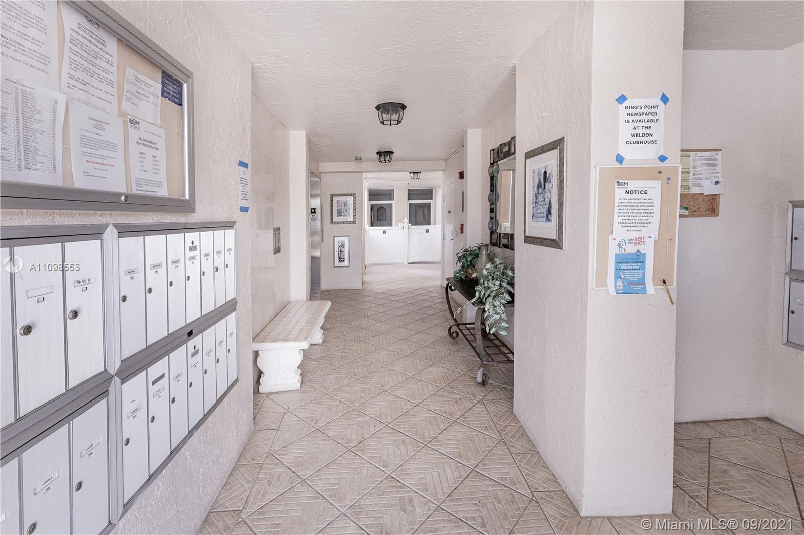 9563 Weldon Circle, Unit D207 Tamarac, FL 33321 - Photo 40 of 40 a hallway with white cabinets and wooden floor
