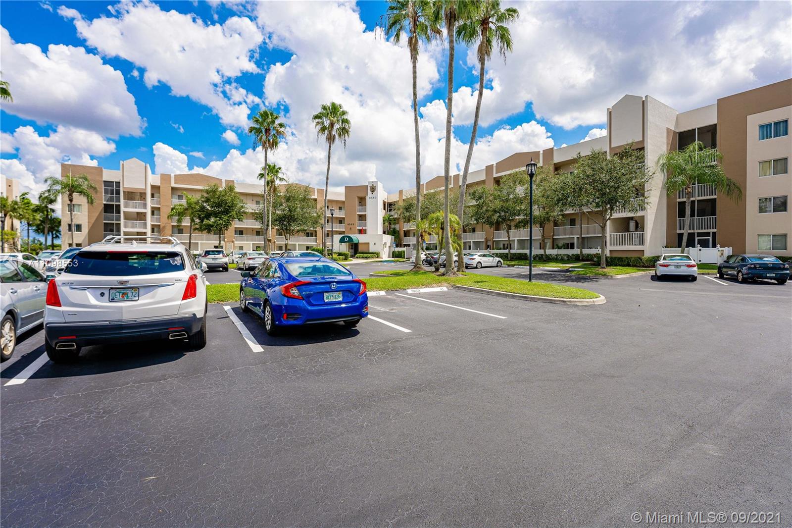 9563 Weldon Circle, Unit D207 Tamarac, FL 33321 - Photo 10 of 40 a cars parked in front of a building
