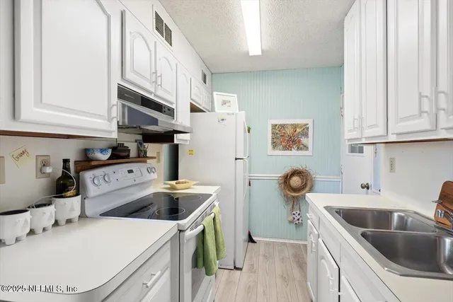 a kitchen with a sink a stove and cabinets