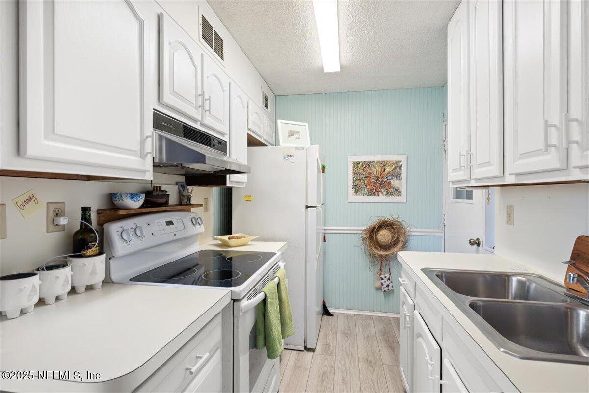 901 Ocean Boulevard, Unit 1 Atlantic Beach, FL 32233 - Photo 19 of 39 a kitchen with a sink a stove and cabinets