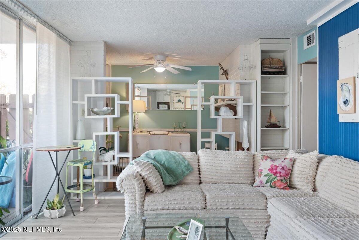 901 Ocean Boulevard, Unit 1 Atlantic Beach, FL 32233 - Photo 21 of 39 a living room with furniture and a floor to ceiling window