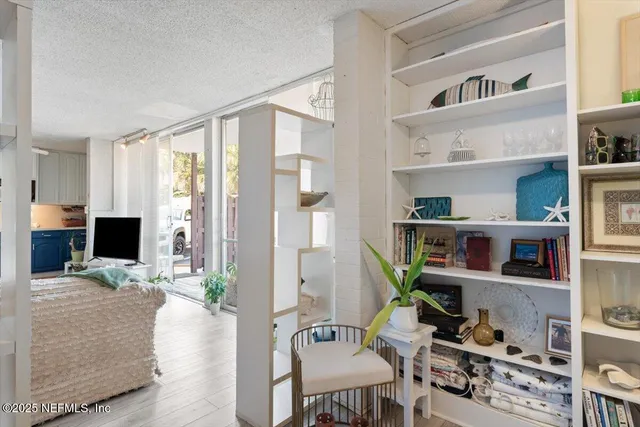 a living room with furniture a flat screen tv and a book shelf