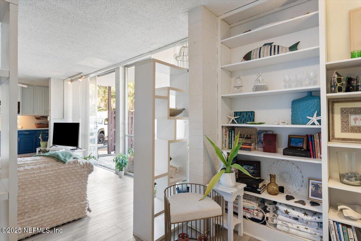901 Ocean Boulevard, Unit 1 Atlantic Beach, FL 32233 - Photo 23 of 39 a living room with furniture a flat screen tv and a book shelf