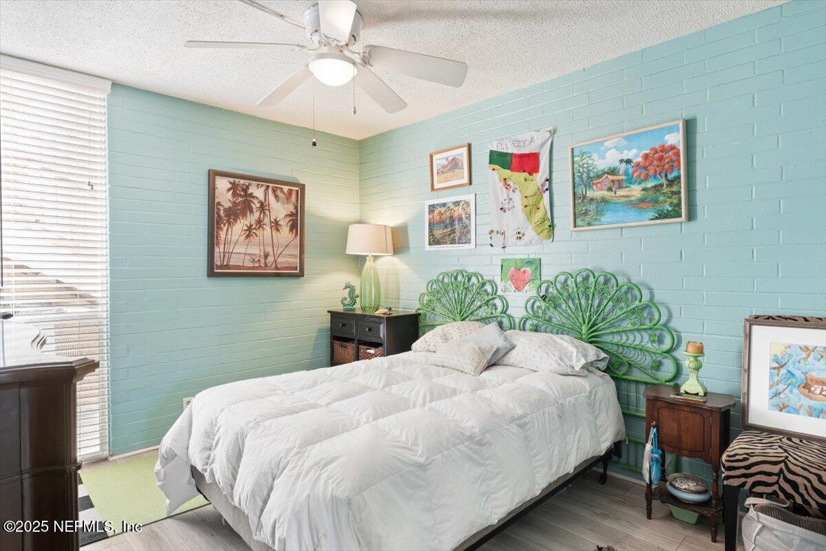 901 Ocean Boulevard, Unit 1 Atlantic Beach, FL 32233 - Photo 24 of 39 a bedroom with a bed and a chandelier
