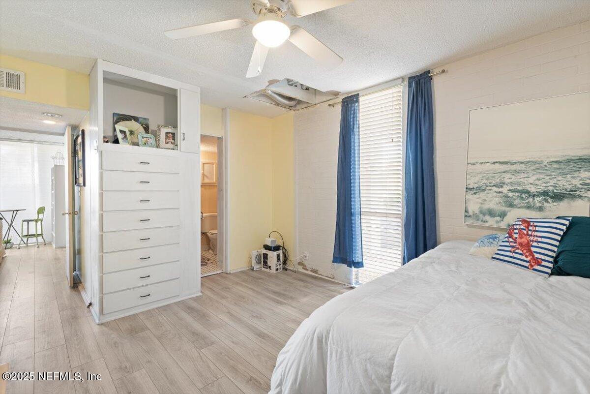 901 Ocean Boulevard, Unit 1 Atlantic Beach, FL 32233 - Photo 29 of 39 a bedroom with a bed and a chandelier