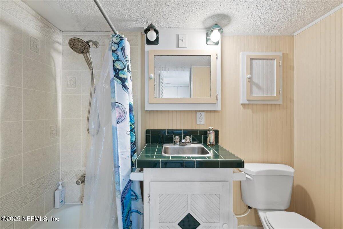 901 Ocean Boulevard, Unit 1 Atlantic Beach, FL 32233 - Photo 30 of 39 a bathroom with a granite countertop sink a toilet and shower