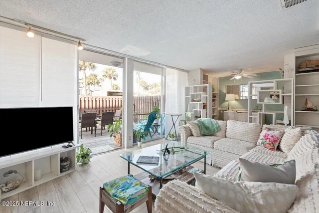 a living room with furniture a flat screen tv and a floor to ceiling window