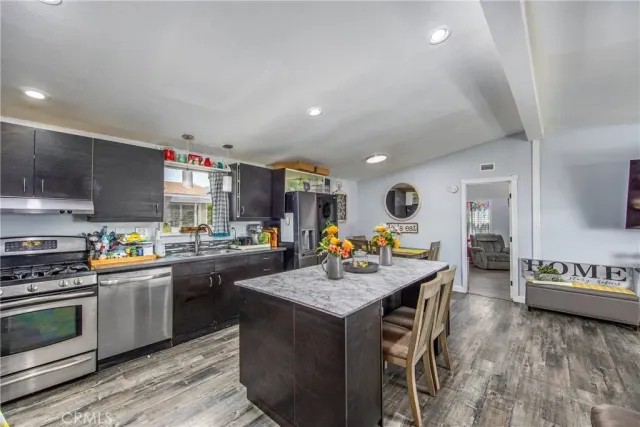 a kitchen with a sink a stove cabinets and wooden floor