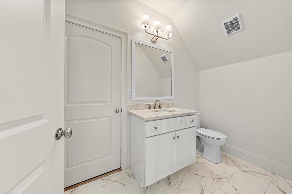 707 Vickery Street Extension Hartwell, GA 30643 - Photo 35 of 50 A well-appointed bathroom boasts pristine white cabinetry, a generous vanity, and elegant tiled flooring.