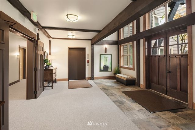 a hall way with furniture and large mirror