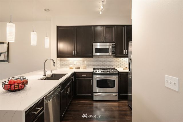 a kitchen with stainless steel appliances a sink stove and microwave