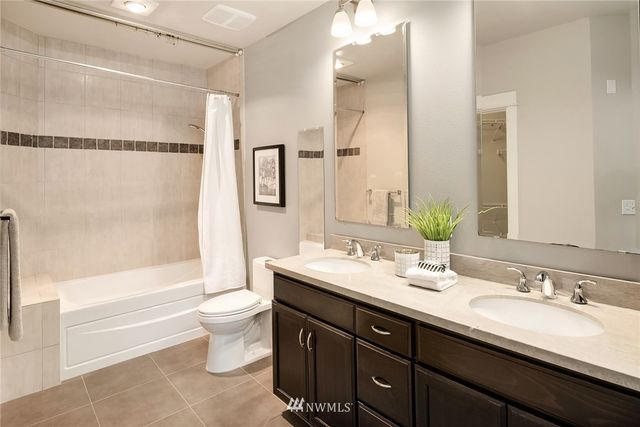 a bathroom with a double vanity sink toilet mirror and shower