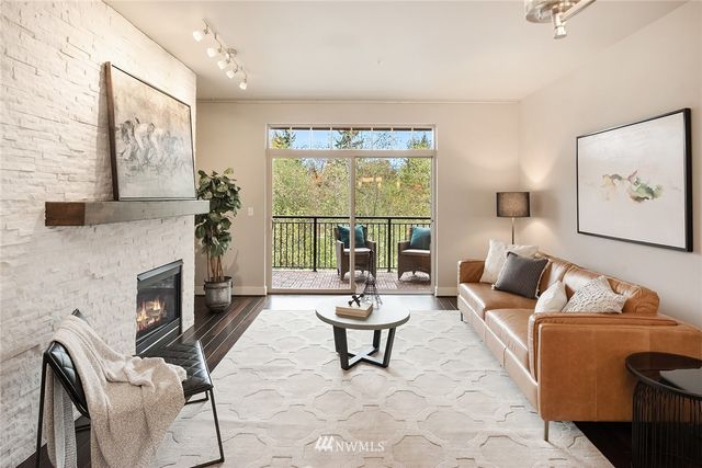 a living room with furniture a fireplace and a large window
