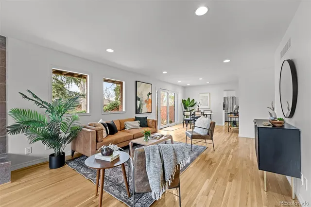 a living room with furniture potted plant and wooden floor