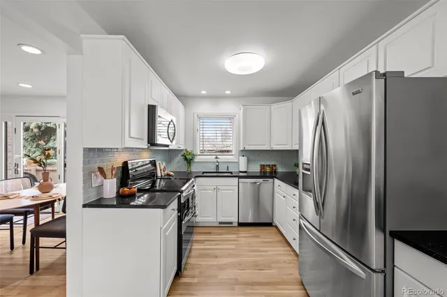 a kitchen with a refrigerator and a stove top oven