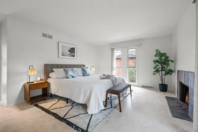a spacious bedroom with a bed and a potted plant