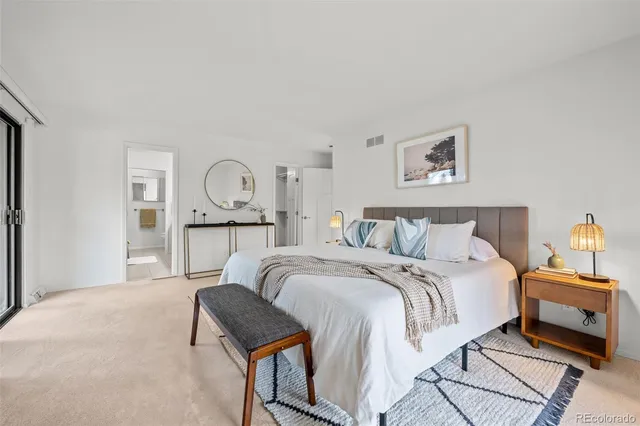 a bed room with a bed and painting on the wall