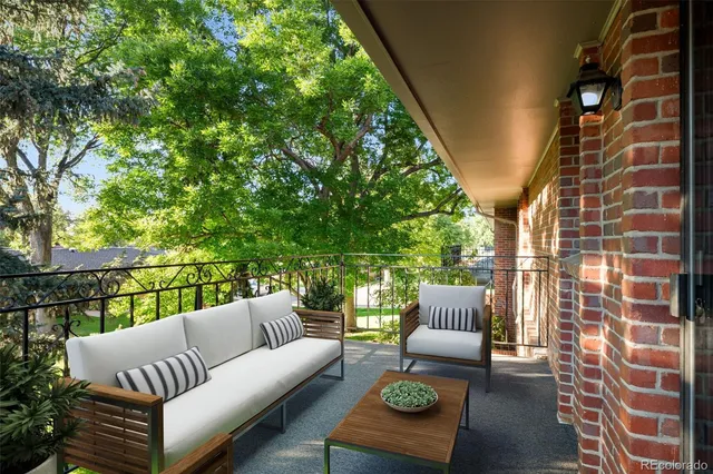 a balcony with couch and a potted plant