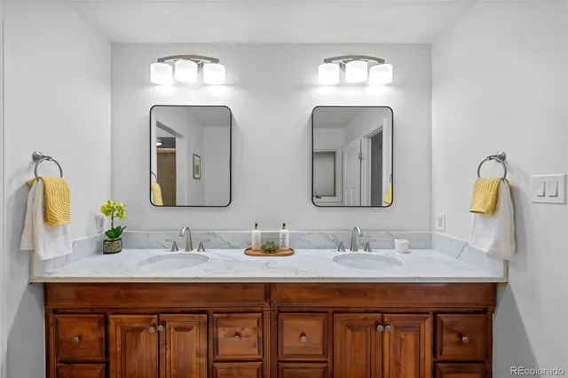 a bathroom with double vanity sinks and a mirror