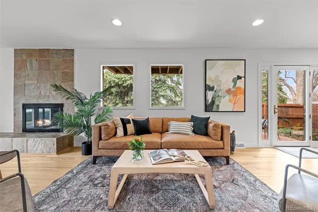 a living room with furniture large window and wooden floor