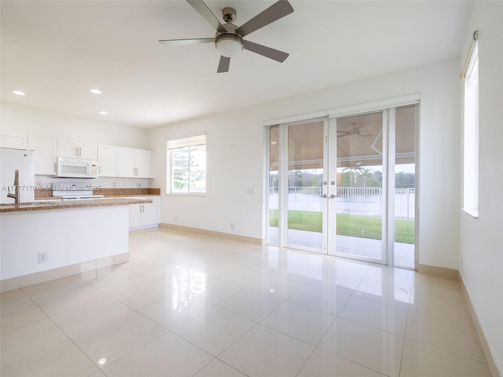 4242 Magnolia Ridge Drive Weston, FL 33331 - Photo 12 of 36 a open kitchen with granite countertop a stove top oven a sink a counter space and a window