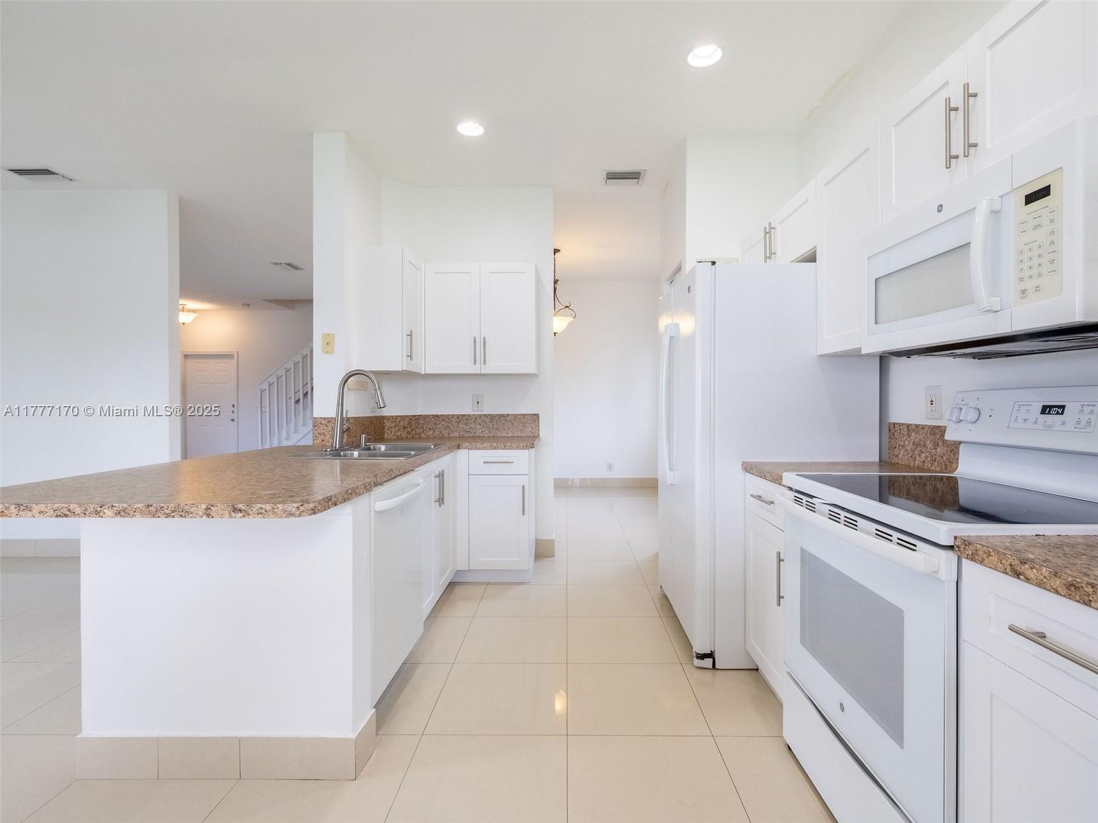 4242 Magnolia Ridge Drive Weston, FL 33331 - Photo 15 of 36 a kitchen with granite countertop a sink and white cabinets
