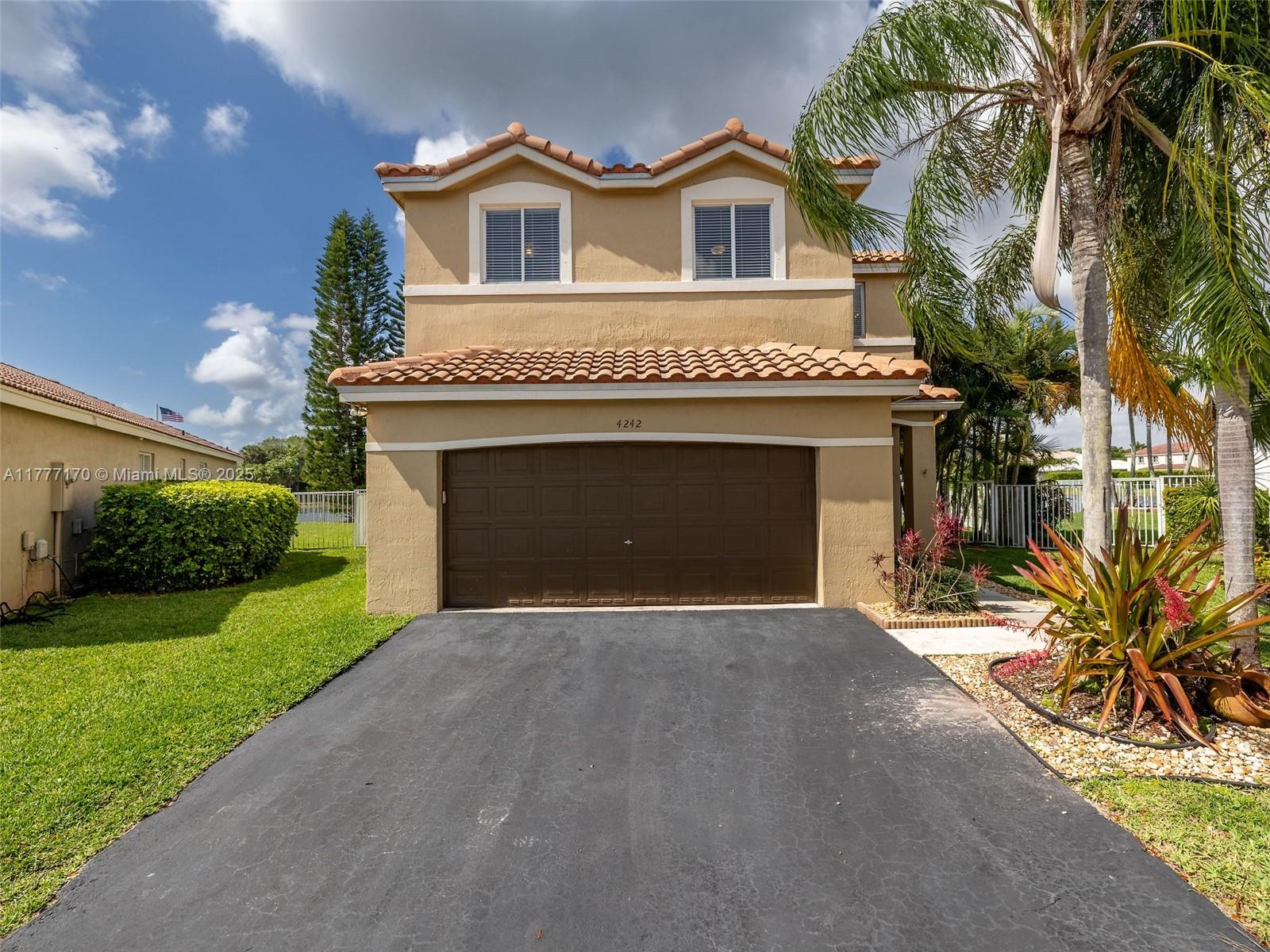 4242 Magnolia Ridge Drive Weston, FL 33331 - Photo 2 of 36 a front view of a house with a yard and garage