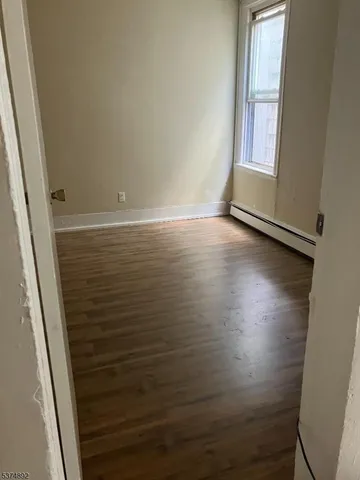 a view of small space with wooden floor and window