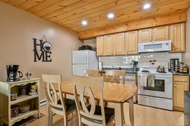 a kitchen with a table chairs microwave and cabinets