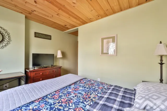 a bedroom with a bed and a flat screen tv