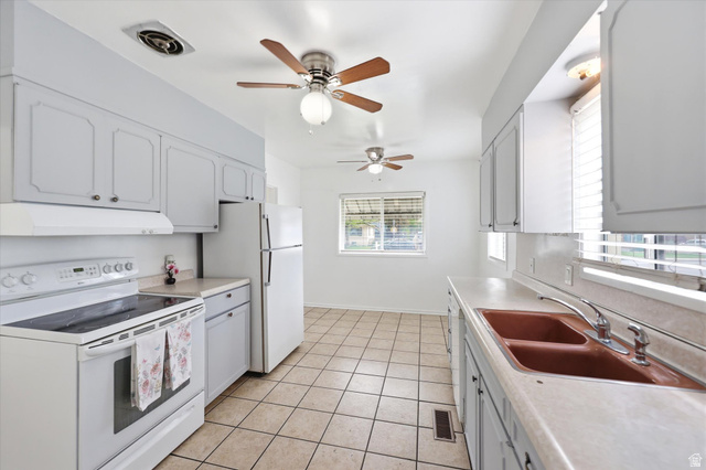 676 South 500 West Provo, UT 84601 - Photo 10 of 29 Kitchen featuring white appliances, light countertops, a ceiling fan, and light tile patterned flooring