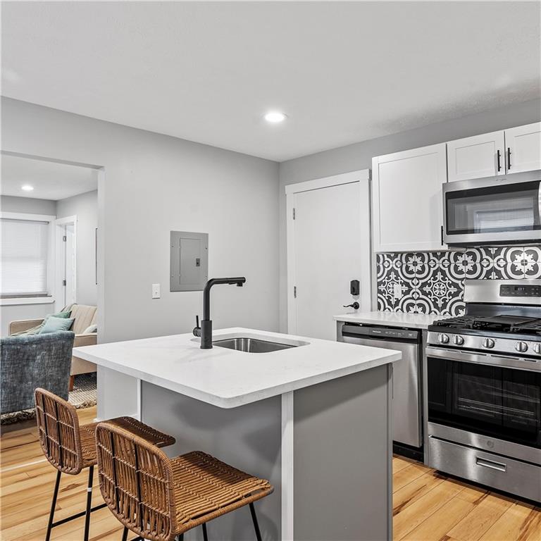 1117-1119 Spring Garden Avenue Pittsburgh, PA 15212 - Photo 11 of 27 a kitchen with a stove a sink cabinets and wooden floor
