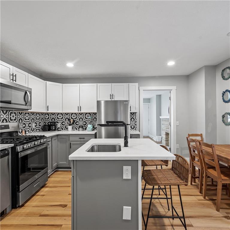 1117-1119 Spring Garden Avenue Pittsburgh, PA 15212 - Photo 9 of 27 a kitchen with granite countertop a stove a sink and a refrigerator