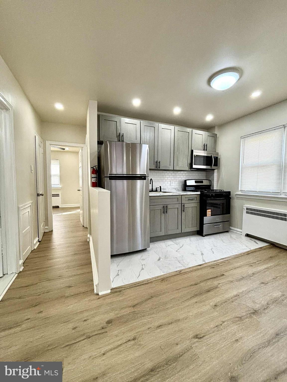 6644 Hollis Street, Unit 1 Philadelphia, PA 19138 - Photo 8 of 14 a view of kitchen with refrigerator stove and wooden cabinets