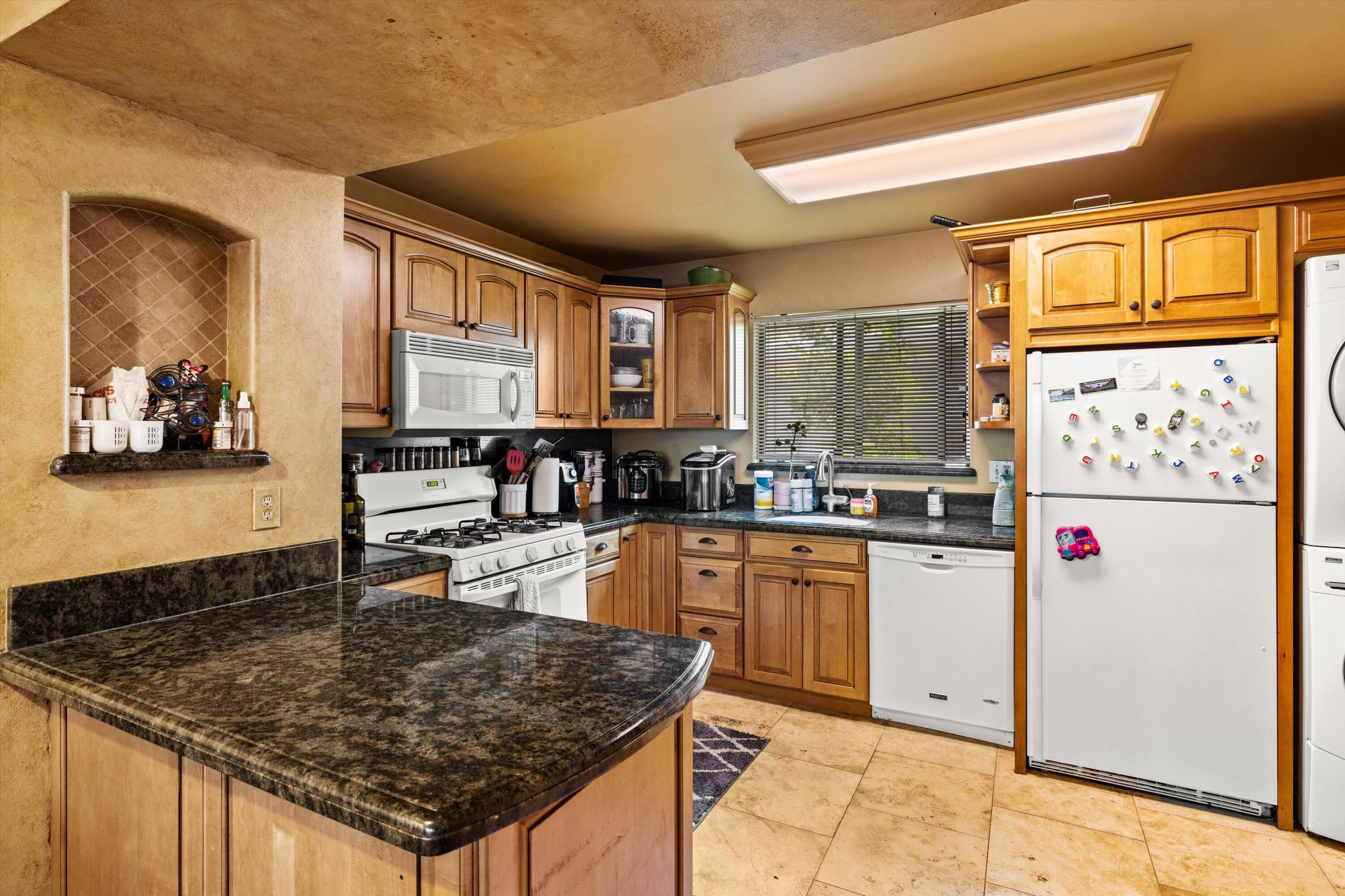 1223 Stonecreek Road, Unit C Santa Barbara, CA 93105 - Photo 6 of 26 a kitchen with stainless steel appliances granite countertop a stove a sink and a refrigerator