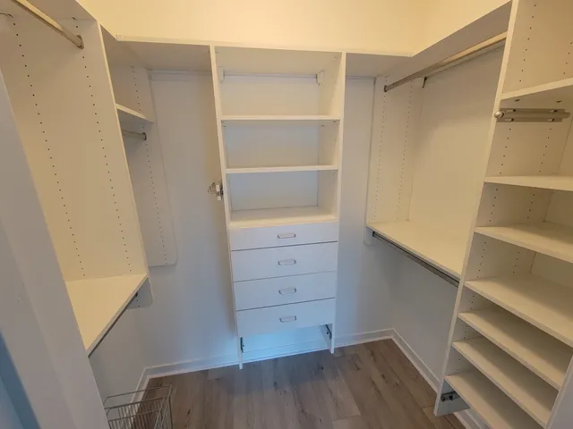 a view of walk in closet with empty racks