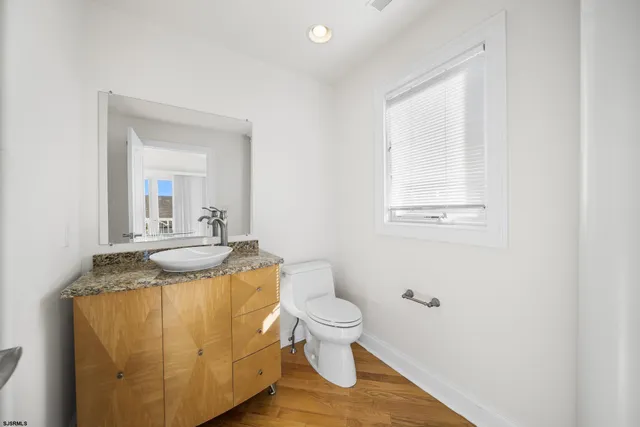 a bathroom with a granite countertop toilet sink and mirror