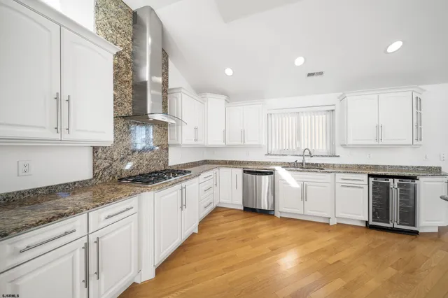 a kitchen with granite countertop white cabinets and white appliances