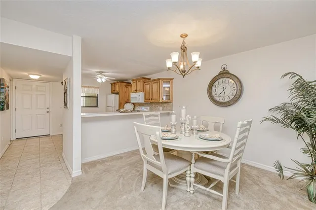 a dining room with wooden floor a chandelier a wooden table and chairs