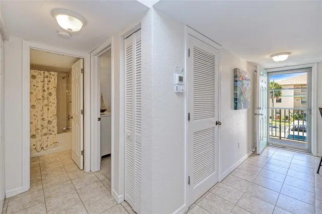 a view of a hallway with bathroom and glass door
