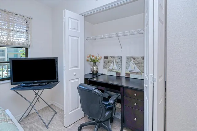 a view of a workspace with furniture and a window