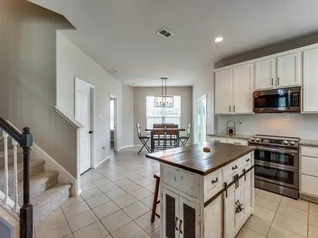 a kitchen with granite countertop a stove a sink and a refrigerator
