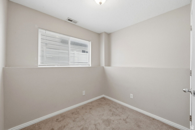 2575 Athena Drive Magna, UT 84044 - Photo 17 of 23 Neutral-toned room featuring a window with white blinds, light beige carpeting, and white baseboards