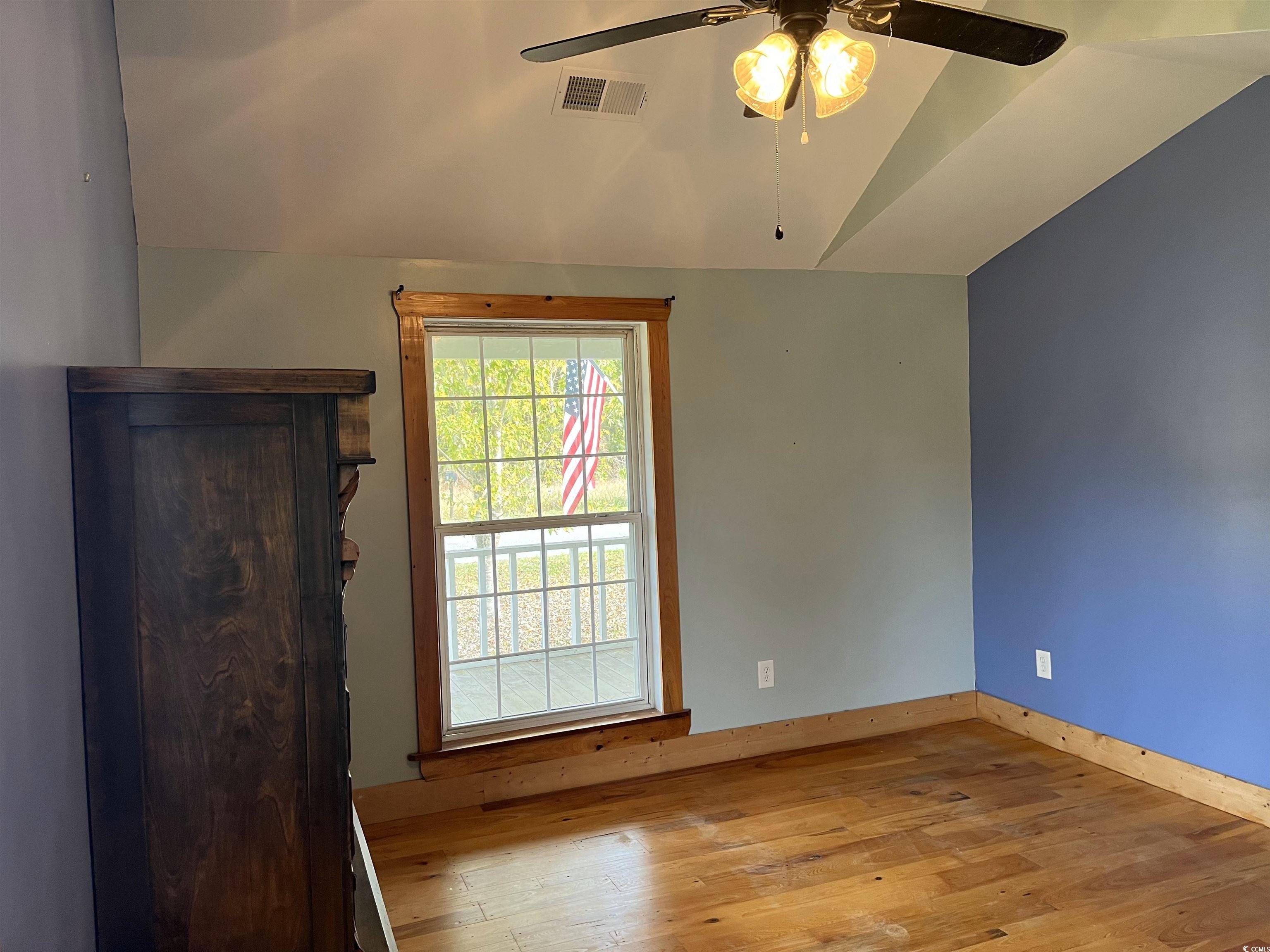 673 Brick Chimney Road Georgetown, SC 29440 - Photo 8 of 25 Unfurnished room featuring lofted ceiling, wood-type flooring, and ceiling fan