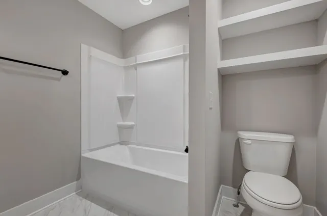 a white toilet sitting next to a bathroom sink