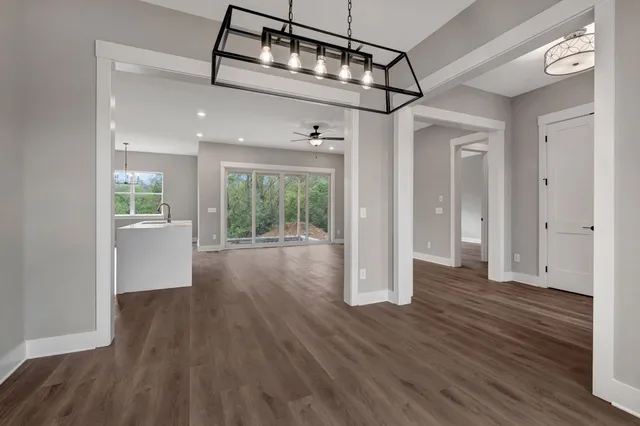 a view of a big room with wooden floor and windows