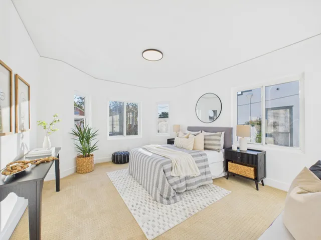 a bedroom with a bed a mirror and a potted plant
