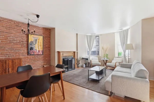 a living room with furniture fireplace and a large window